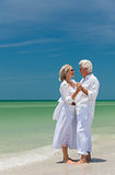 Happy Senior Couple Dancing Holding Hands on Beach