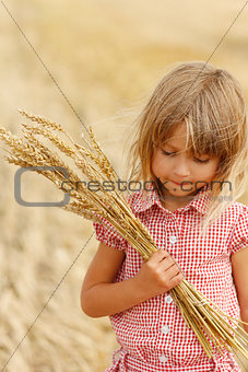 little girl on the field with wheat