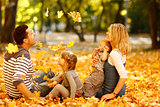 young family playing in autumn park outdoors