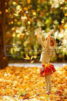 beautiful little girl in the autumn park playing in nature
