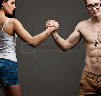 man VS woman in an arm wrestling 
