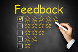 hand writing feedback on black chalkboard golden rating stars