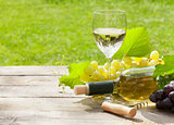 White wine glass and bottle with bunch of grapes