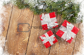 Old wood texture with snow, gift boxes and firtree