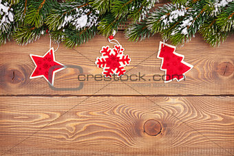 Christmas fir tree with snow and holiday decor on rustic wooden 