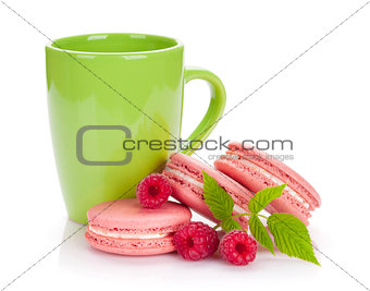 Pink raspberry macaron cookies and cup of drink