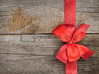 Wooden background with red bow and ribbon