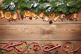 Christmas wooden background with snow fir tree, spices and ginge