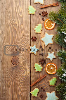 Christmas background with snow fir tree, spices and gingerbread 