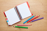 Office table with blank notepad and colorful pencils