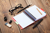 Office table with notepad, colorful pencils and supplies