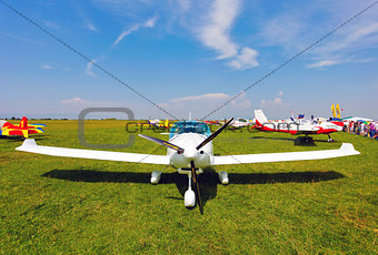 White airplane on a green grass field