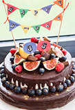 Chocolate cake with icing, decorated with fresh fruit