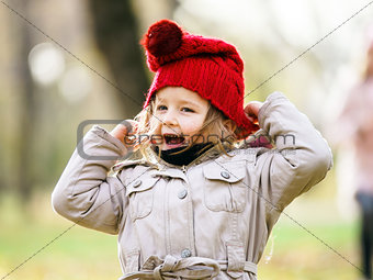 Cute little girl on playground in autumnal park