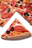 Tasty pizza with ham, tomatoes and olives with a slice removed 