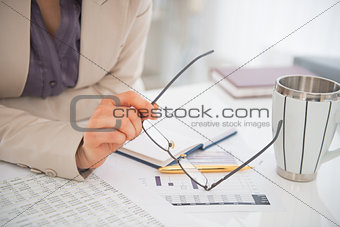 Closeup on business woman holding eyeglasses