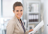 Portrait of happy business woman with documents in office