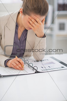Stressed business woman with documents at work