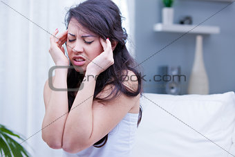 girl with painful headache in her living room