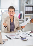 Portrait of happy business woman in office rejoicing
