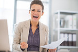 Portrait of happy business woman in office rejoicing