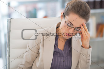 Portrait of stressed business woman with eyeglasses in office