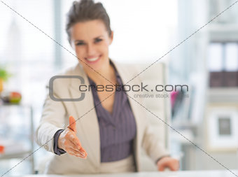 Closeup on happy business woman stretching hand for handshake in