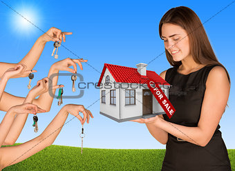 Beautiful girl holding house with label. Many hands are given keys
