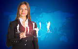 Beautiful businesswoman in suit presses finger on virtual button. World map and business silhouettes