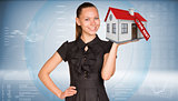 Businesswoman smiling and holding house in hand