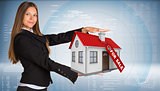Businesswoman smiling and holding house in hand