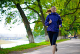 Young Beautiful Woman Running in the Autumn Park