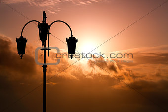 Silhouette of black street lamp against the background beautiful expressive cloudy sky.
