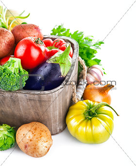 Fresh vegetables in wooden bucket with greens