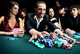 Poker player going "all in" pushing his chips forward