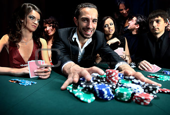 Poker player going "all in" pushing his chips forward