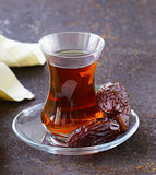 Turkish tea in traditional glass with sweet dates