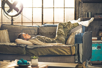Relaxed young woman laying in loft apartment