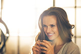 Portrait of smiling young woman with cup of coffee