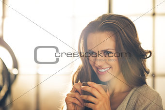 Portrait of smiling young woman with cup of coffee