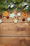 Christmas wooden background with snow fir tree, spices, gingerbr