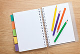 Office table with blank notepad and colorful pencils