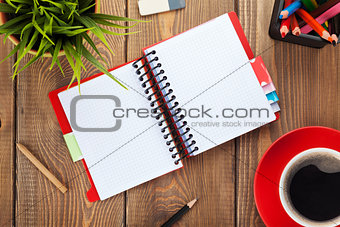Office table with flower, blank notepad and coffee cup