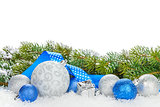 Christmas baubles and blue ribbon with snow fir tree