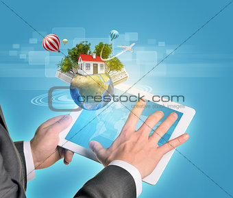 Man hands using tablet pc. Earth with buildings and trees near computer