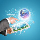 Man hands using tablet pc. Business city on touch screen. Earth near computer