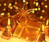 Golden Christmas gift with baubles decorations and candles