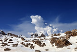 Snowy rocks and sky with clouds at nice day