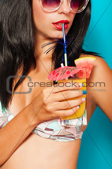 Beautiful girl in bikini with a cocktail