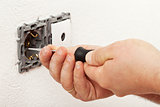 Electrician hand mounting a wall fixture